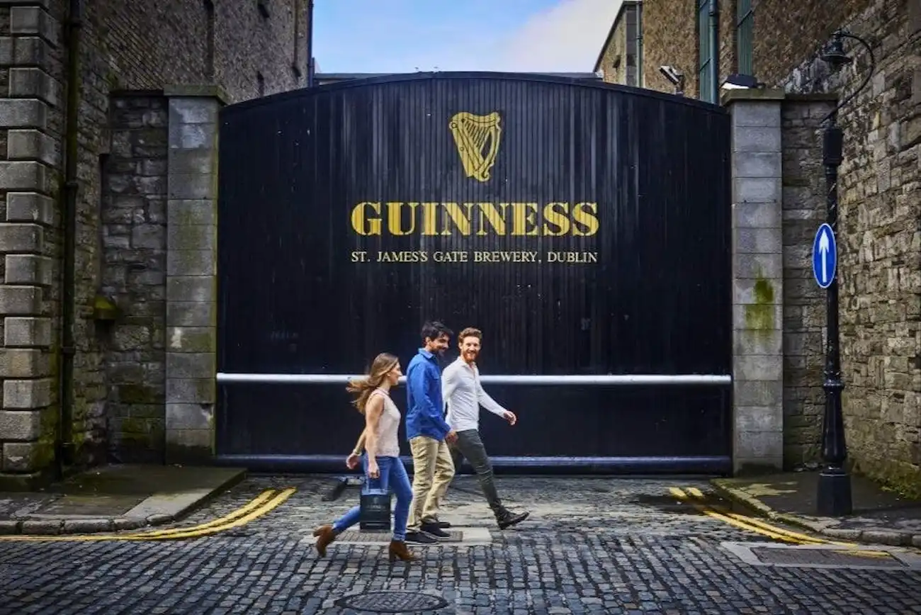 A couple walking happily past the legendary Guinness St. James's Gate in Dublin.