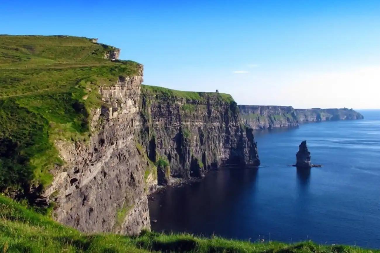 Take the ultimate day trip to Ireland's west coast and see the spectacular Cliffs of Moher. A stunning view of the dramatic, towering Cliffs of Moher dropping steeply into the blue Atlantic Ocean.
