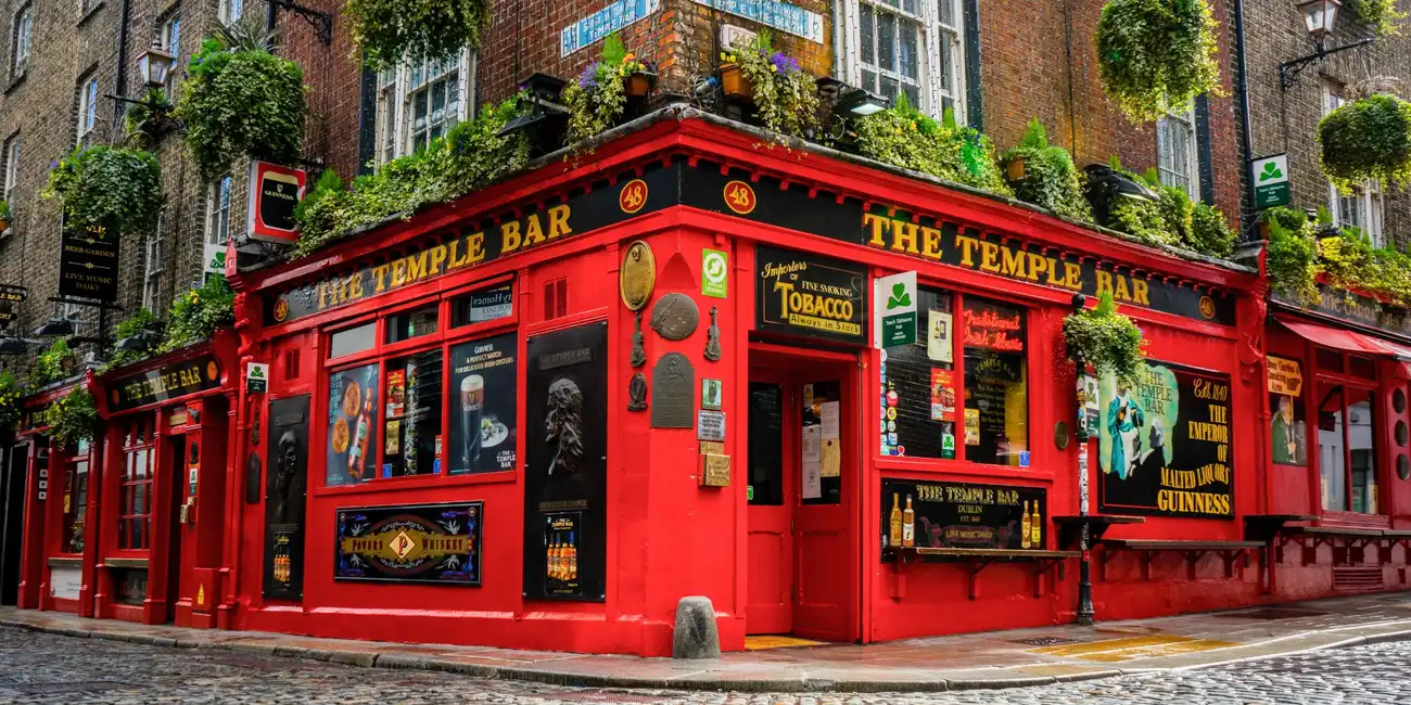 Colorful exterior of Temple Bar, a traditional Irish pub, on a cobbled street in Dublin, Ireland - Best Things to Do in Dublin with Dublin City Pass.