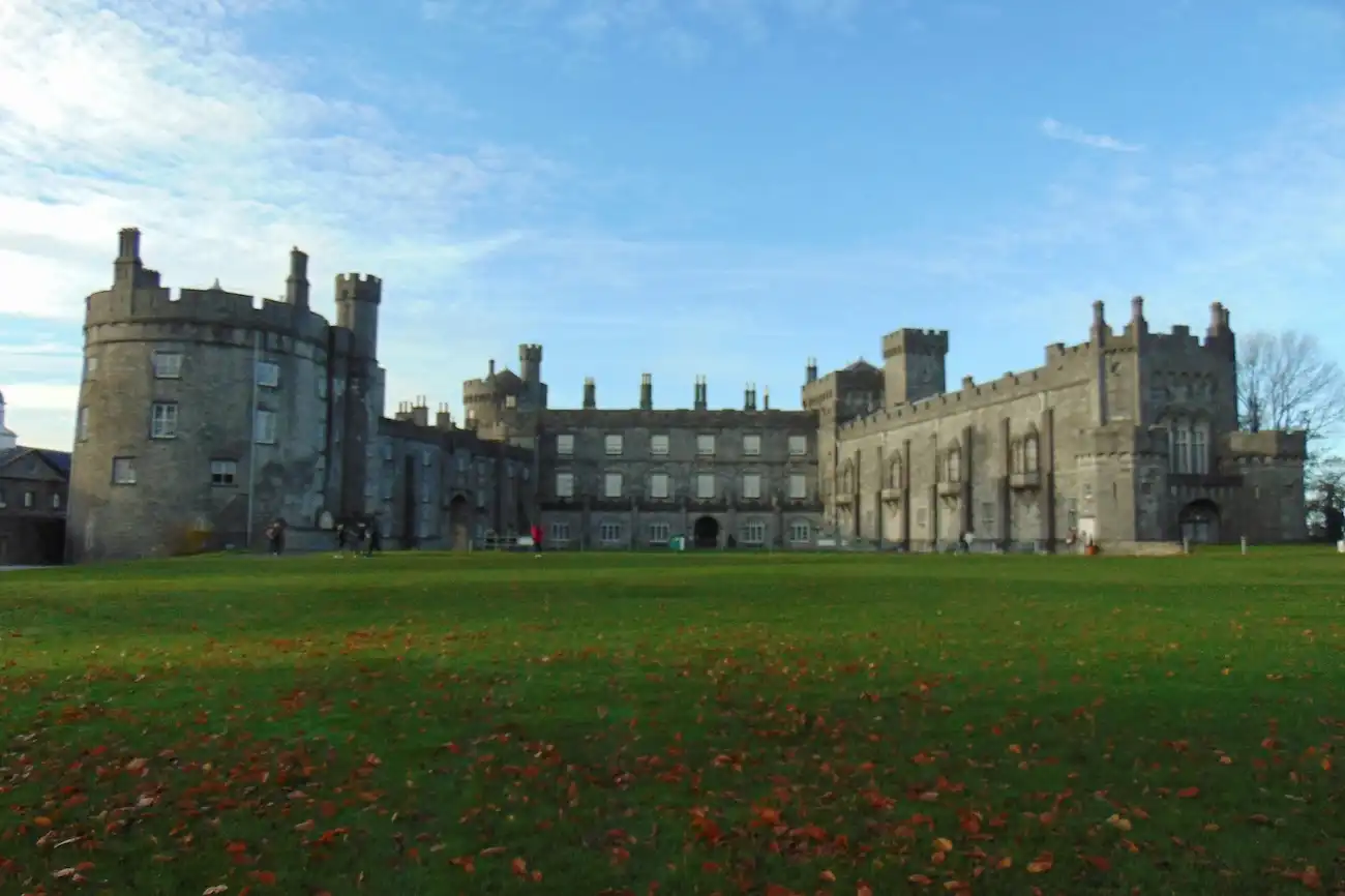 Exterior view of the historic Kilkenny Castle and its sprawling green lawns.
