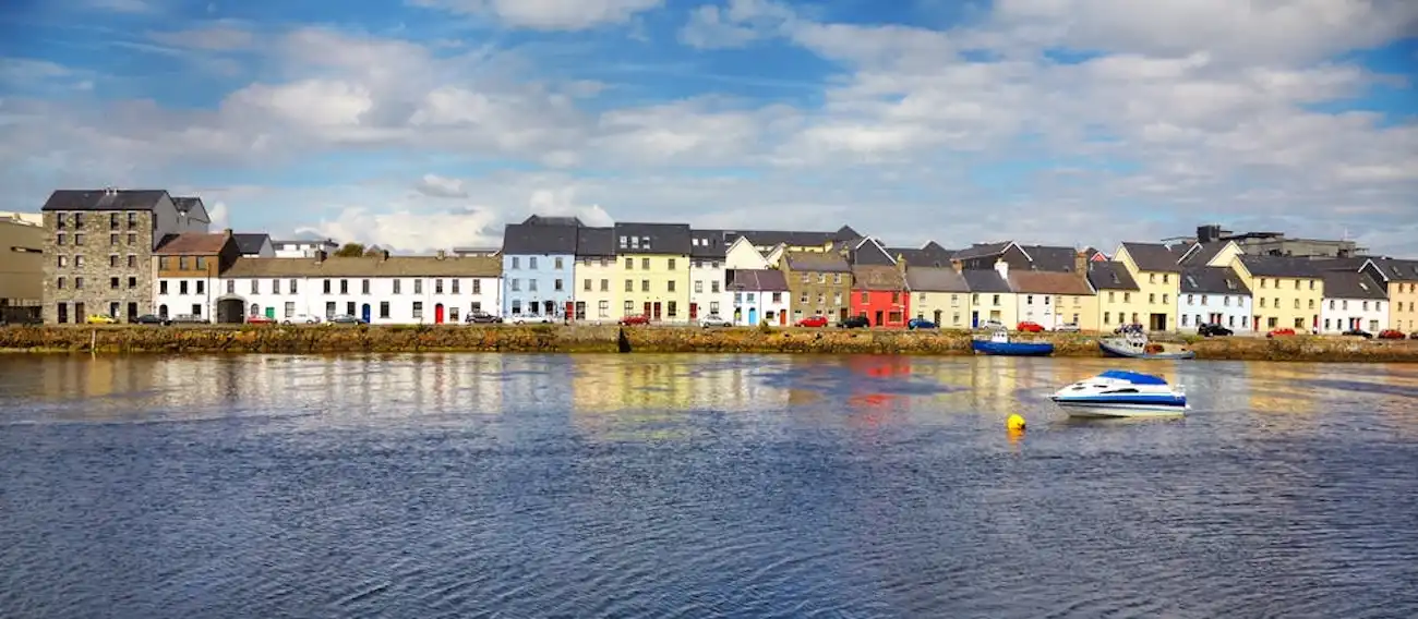 Take in the charming, traditional atmosphere of Ireland's cultural heart on the west coast. A picturesque row of brightly colored houses sitting along the waterfront in Galway City.
