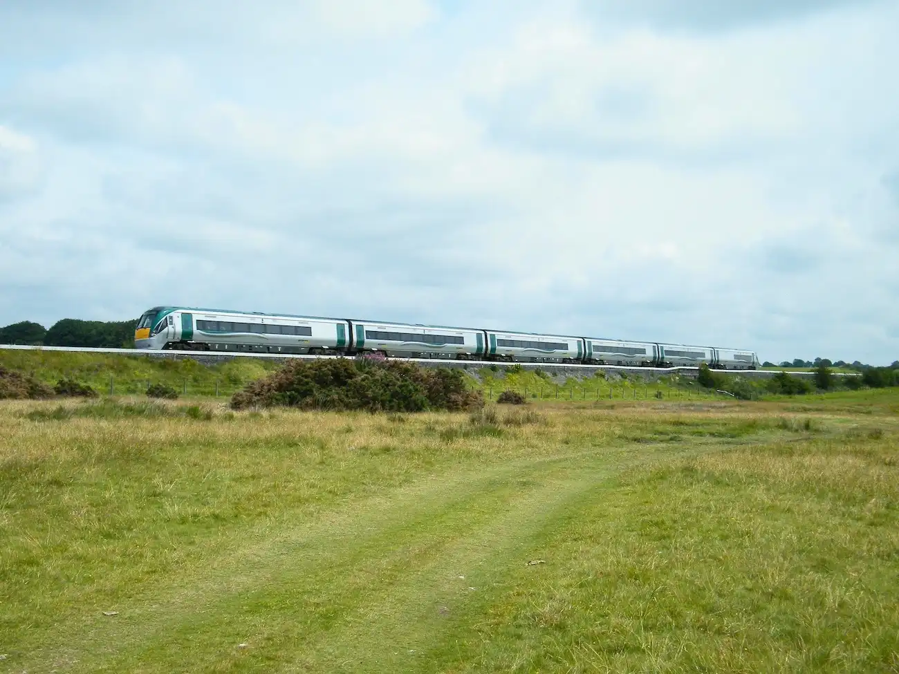 An Irish Rail intercity train traveling through the lush green countryside of Ireland.