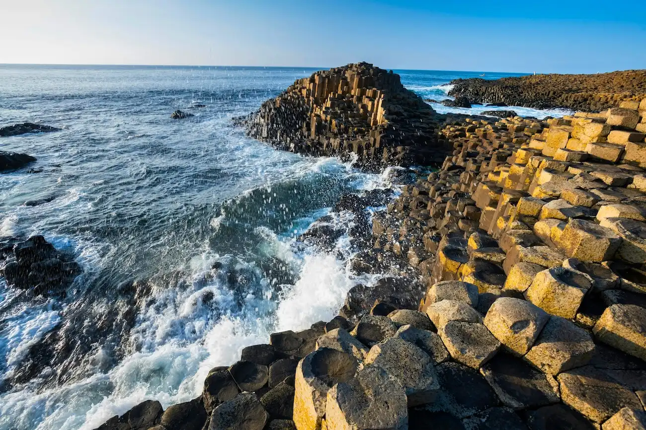 Vagues de l'océan se fracassant contre les formations rocheuses volcaniques uniques de la côte d'Antrim.