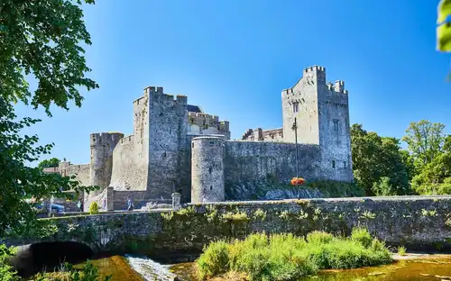 An epic view of a historic Irish castle surrounded by lush green countryside.